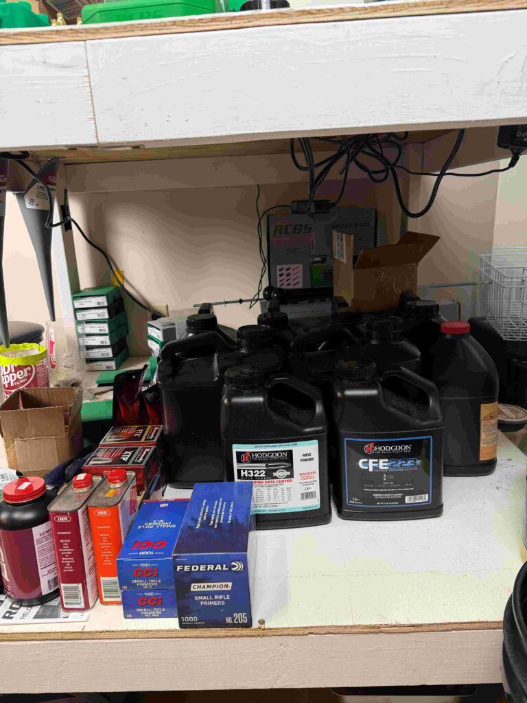 The bottom shelf of a 4x8 reloading bench that accommodates multiple 8 pound Hodgdon powder kegs, additional RCBS dies, and other equipment.