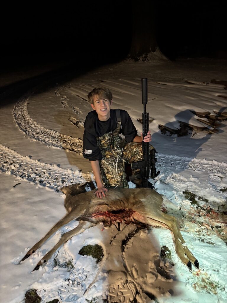Boy showing field dressed deer