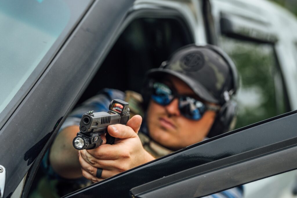 man shooting out of car window