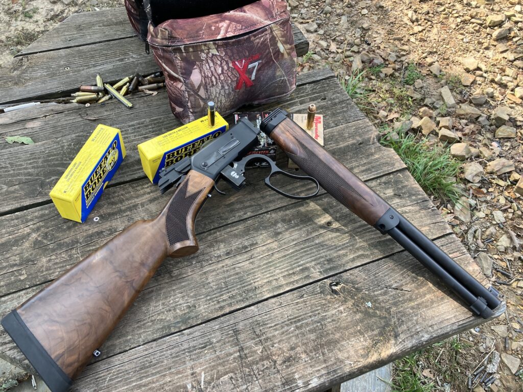 rifle on wooden bench with boxes of ammunition